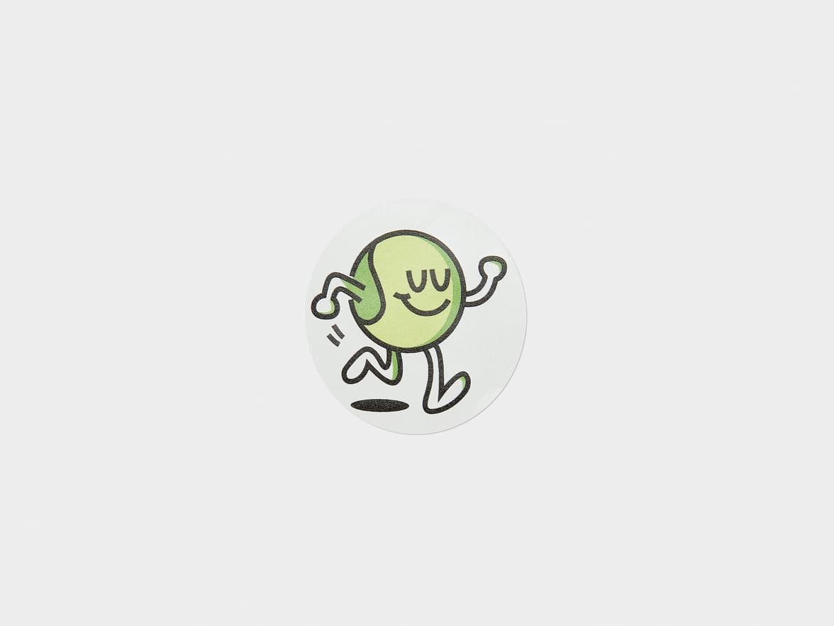 A customized clear round sticker with a green cartoon character printed on it.